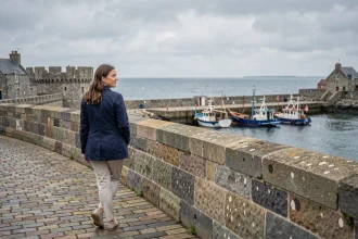 Femme se promenant sur les remparts médiévaux de Concarneau avec vue sur le port breton